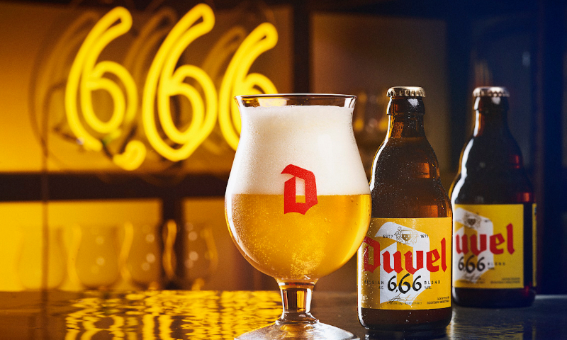 Duvel 666 bier in glas en flesjes op tafel met een 666 neon lamp erachter